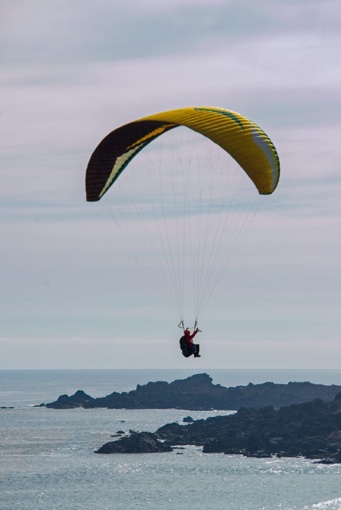 Parapente sobre las rocas y el mar
